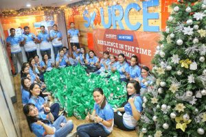 sourcefit employees sitting down with green donation bags